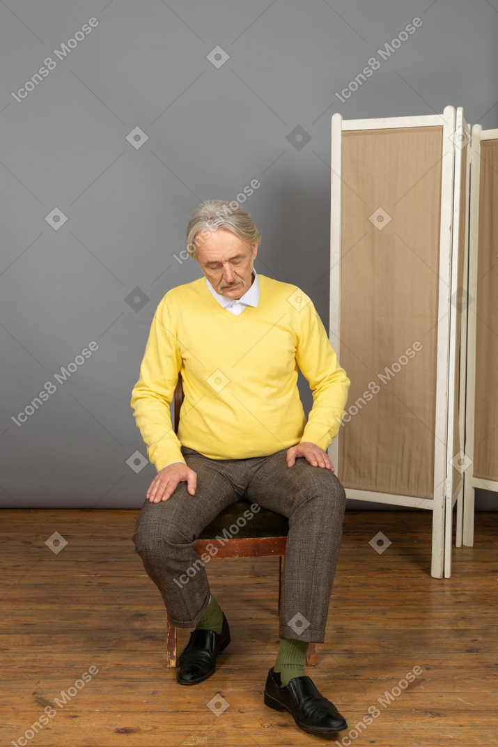 Uomo di mezza età che si alza da una sedia