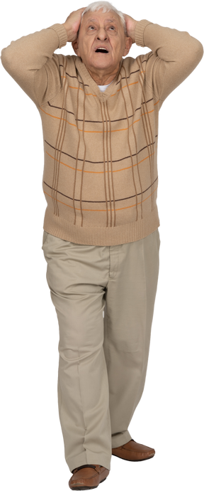 Вид спереди впечатленного старика в повседневной одежде, стоящего с руками за головой