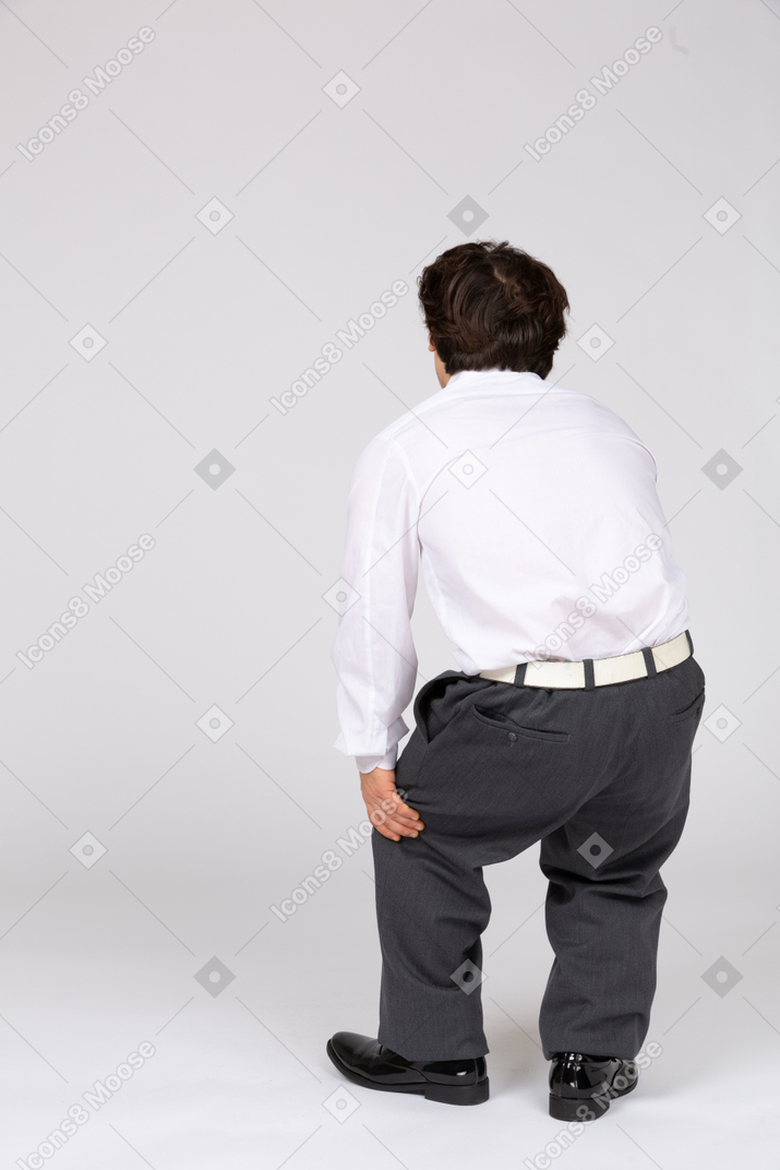 Rear view of man feeling pain in leg