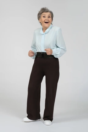 Front view of an old woman dancing and smiling