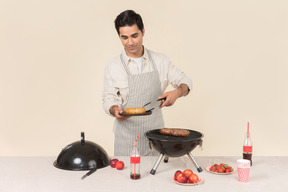 Hombre caucásico joven cocinando barbacoa