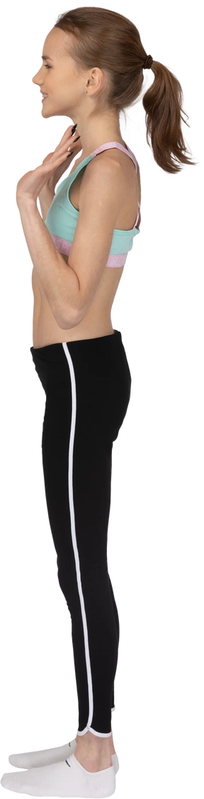 Side view of a teen girl in sportswear smiling and waving hand