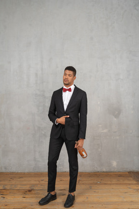 Tipsy young man standing with a bottle in his hand