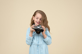 Bambina carina che tiene una macchina fotografica