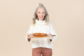 Elegant old woman offering to try her homemade pie