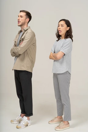 Three-quarter view of young couple showing tongues