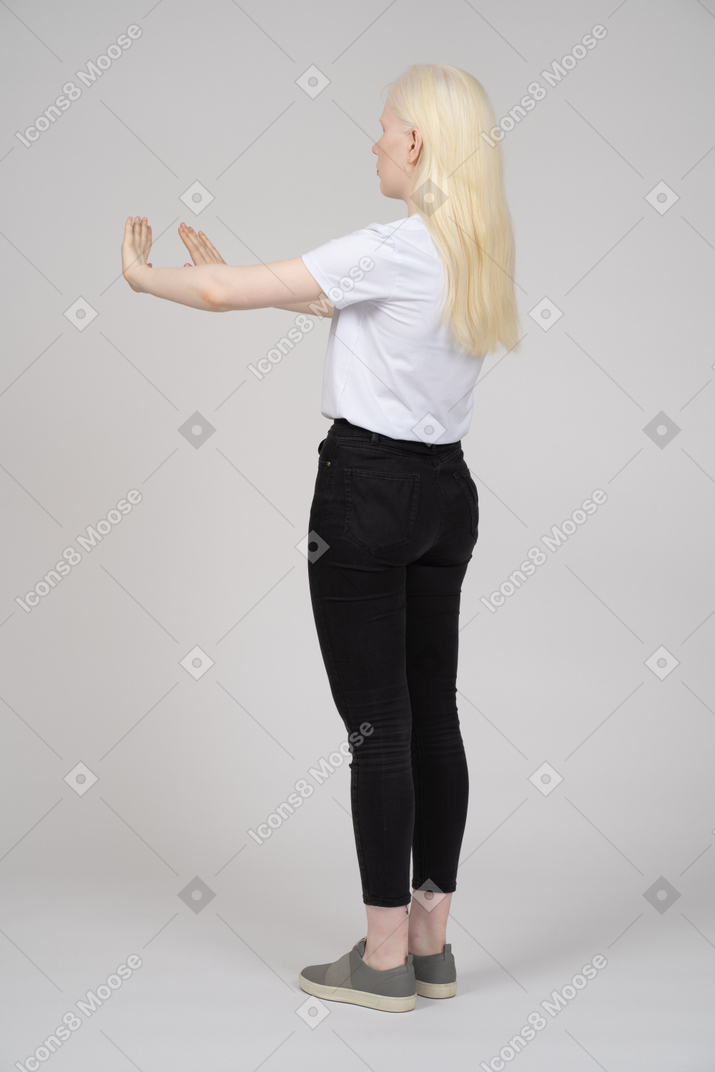 Back view of a blonde woman extending her arms