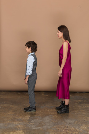 Boy and woman standing still in profile