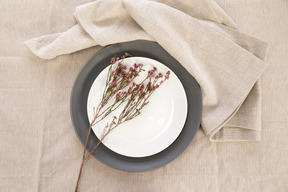 Black and white plates and twig on tablecloth