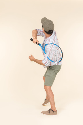 Jeune, caucasien, tenue, raquette tennis, et, dos, appareil photo