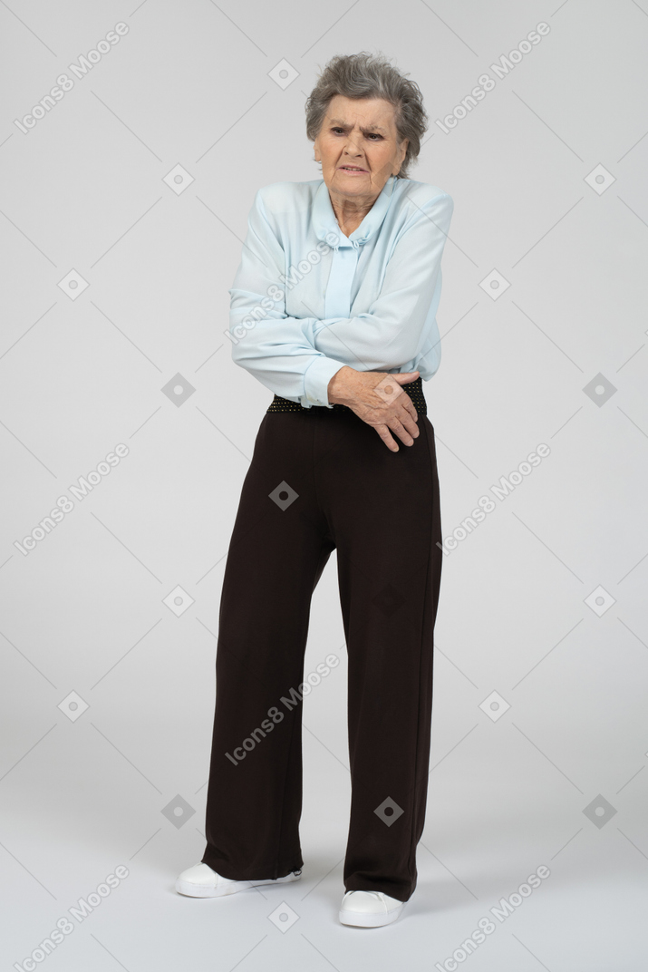 자신을 껴안고 있는 노인 여성의 전면 모습