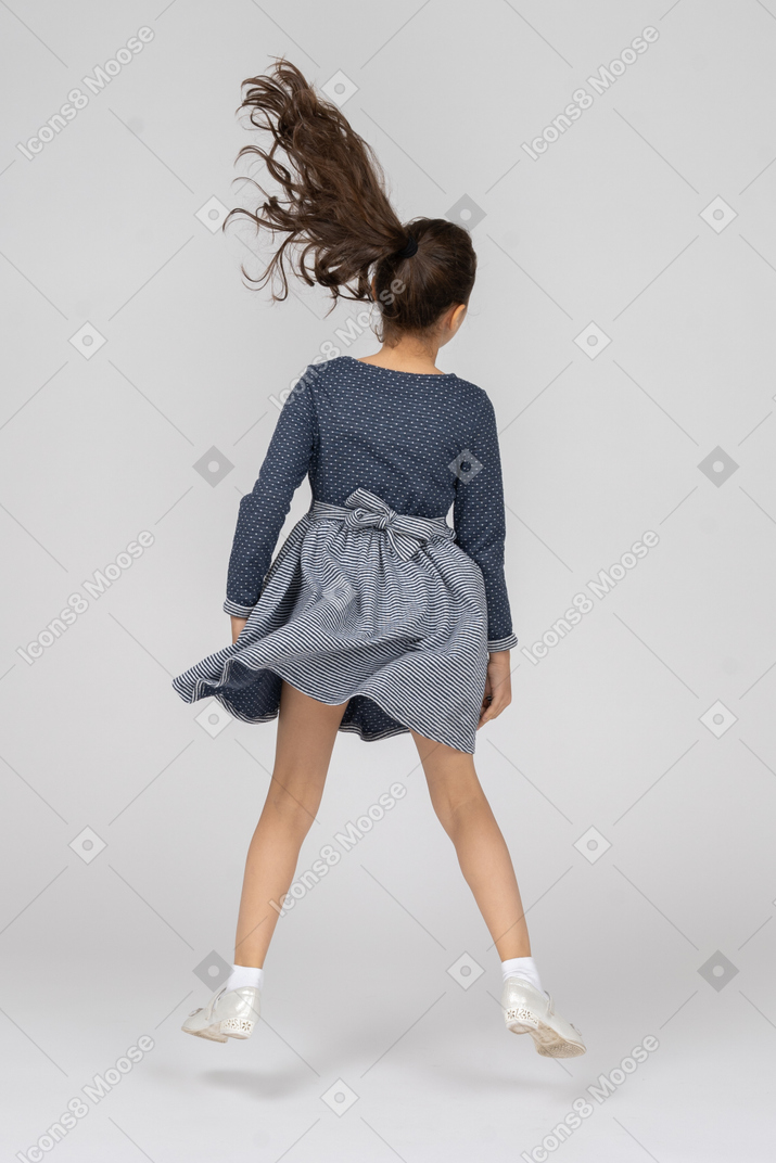 Vista traseira de uma garota pulando em movimento