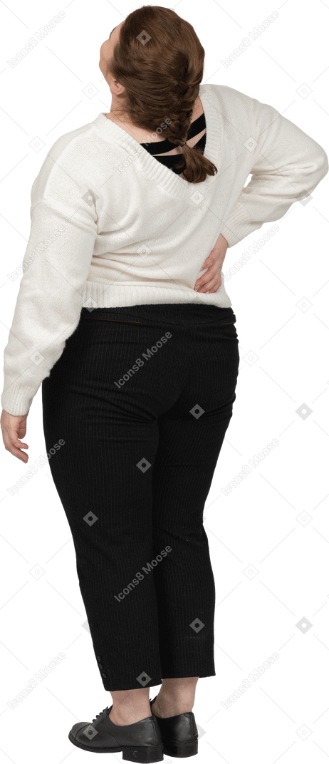 Femme de taille plus en pull blanc souffrant de douleurs dans le bas du dos