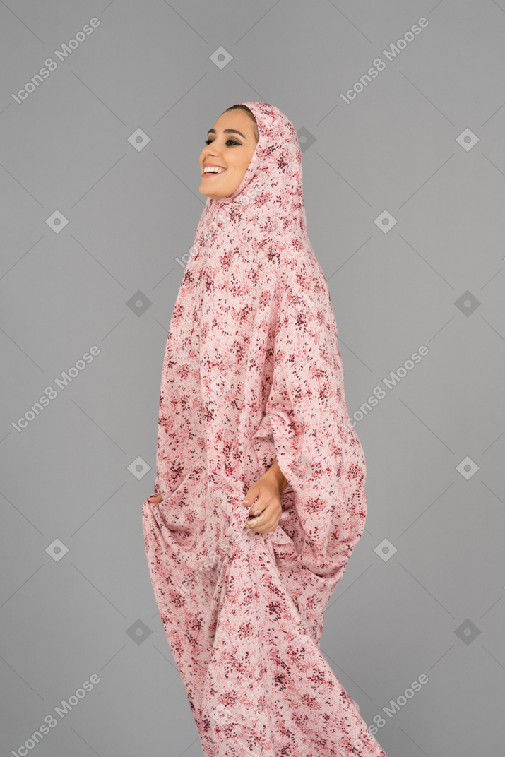 祈りのドレスを着て笑顔のイスラム教徒の女性