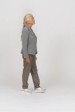 Side view of an old lady in suit walking