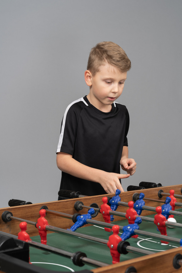 Three-quarter view of a boy playing foosball