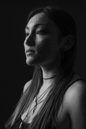 Black and white photo of woman wearing ethnic makeup