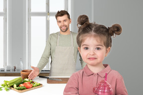 A little girl and a man cooking in a kitchen