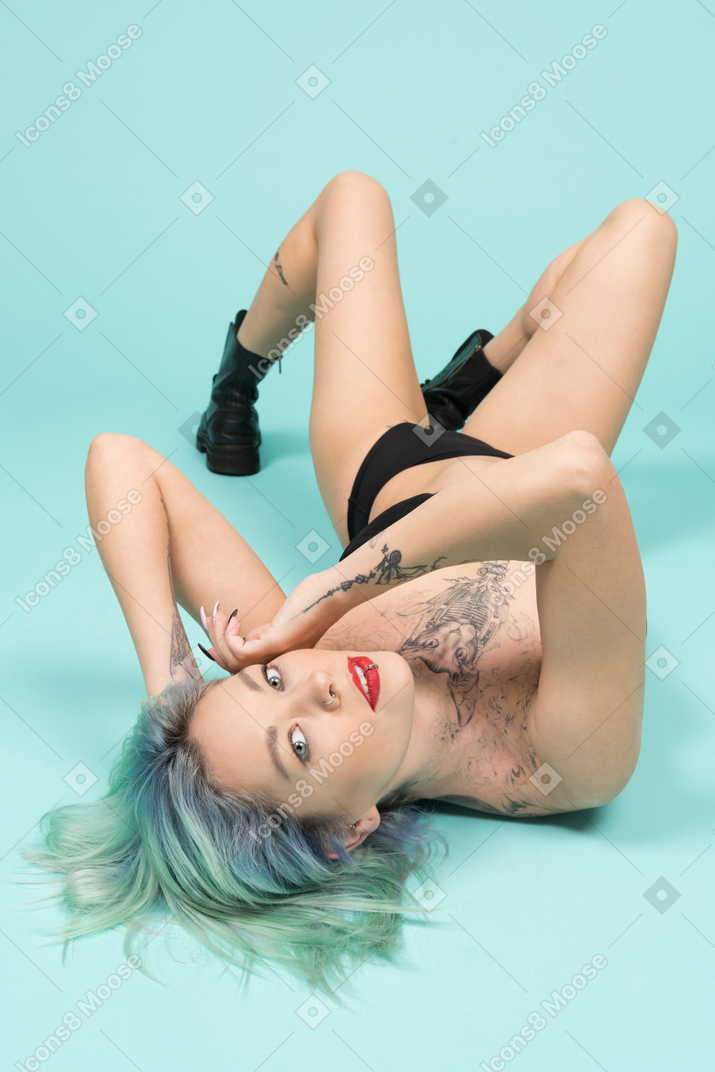 Femme sexy en lingerie noire posant sur le sol