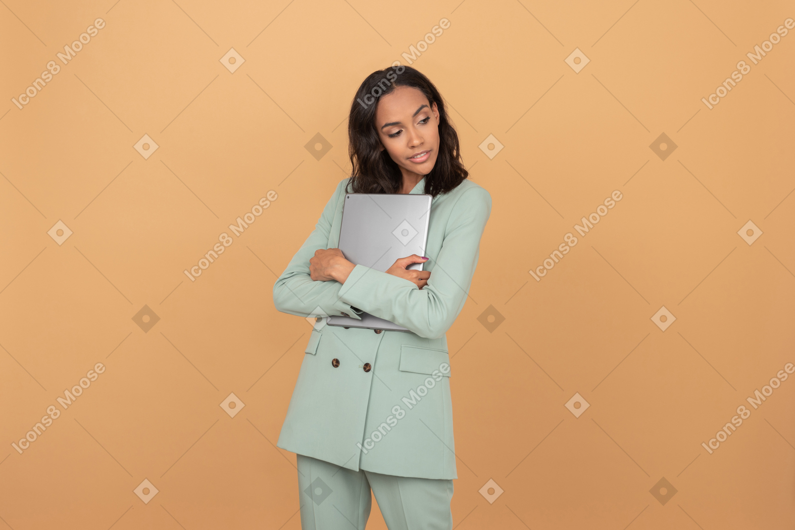 Atractiva mujer sosteniendo una tableta cerca de ella y mirando a un lado algo con interés