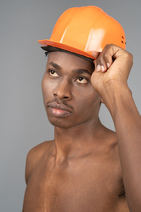 Jovem nu usando capacete de construção