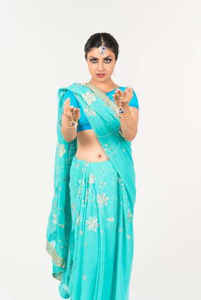 Jeune femme indienne en sari bleu debout en position de danse