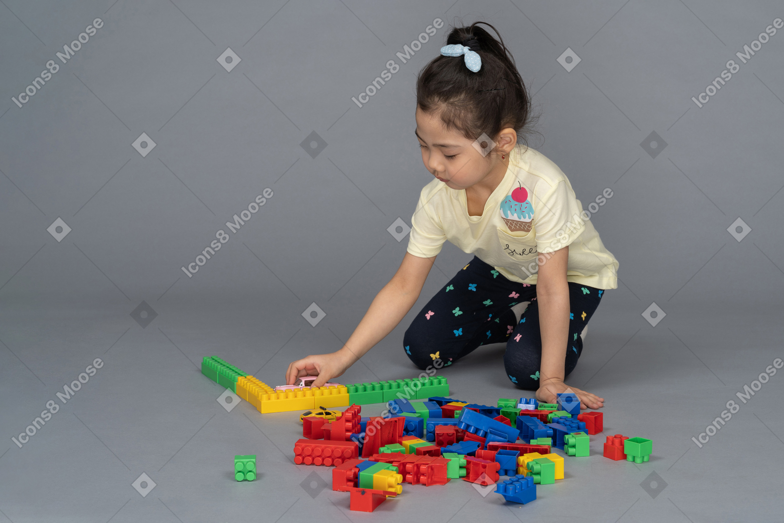 Маленькая девочка играет со строительными блоками