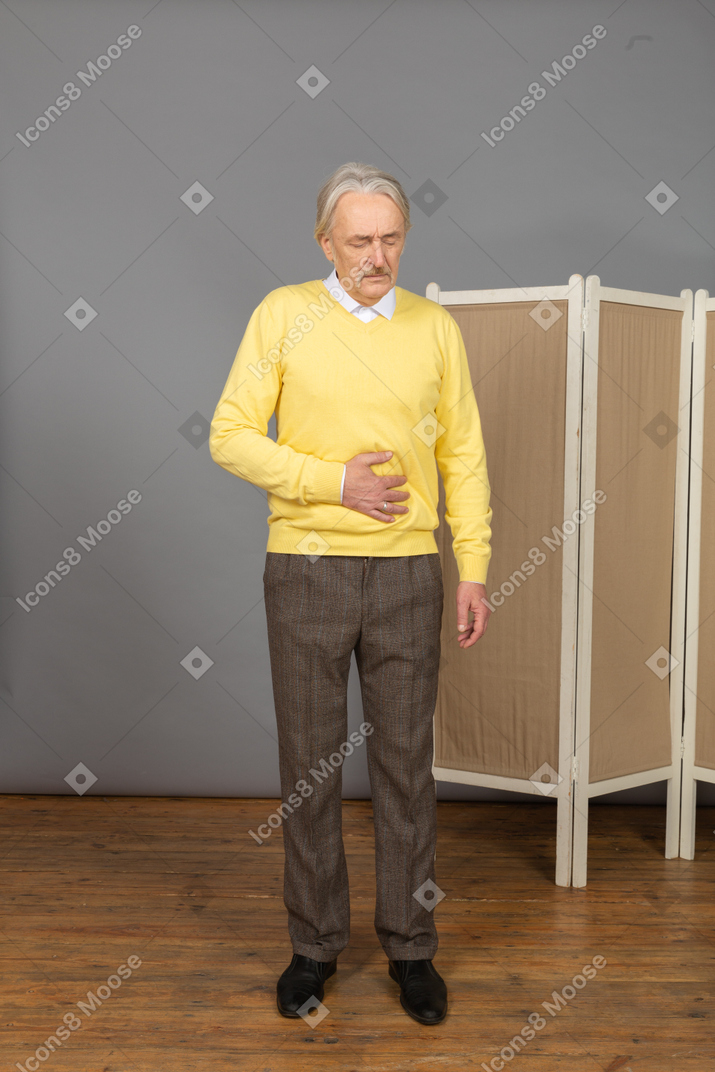 Front view of an old man having a stomach ache