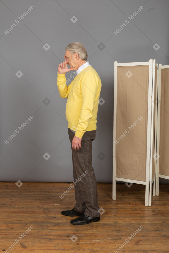 Side view of an old man touching his nose