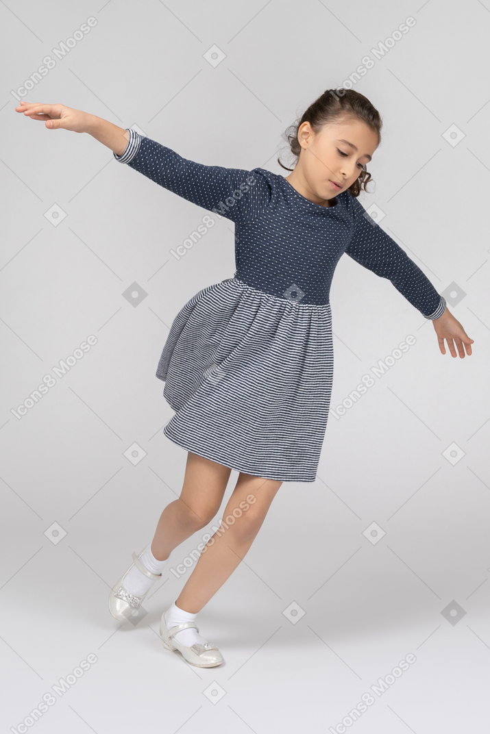 Three-quarter view of a girl imitating flying like an airplane