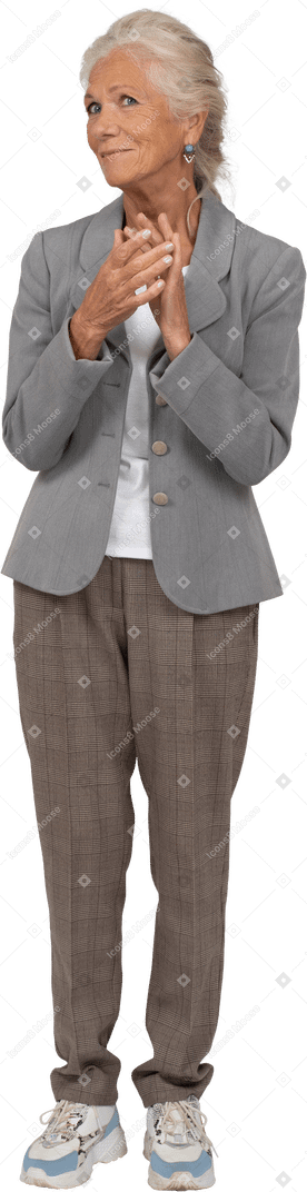 Front view of a happy old lady in suit clapping hands