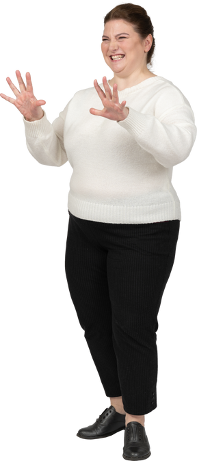 Feliz mujer de talla grande en suéter blanco posando