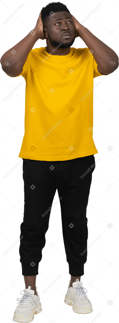 一个身穿黄色 t 恤、摸头和抬头的黑皮肤年轻男子的前视图