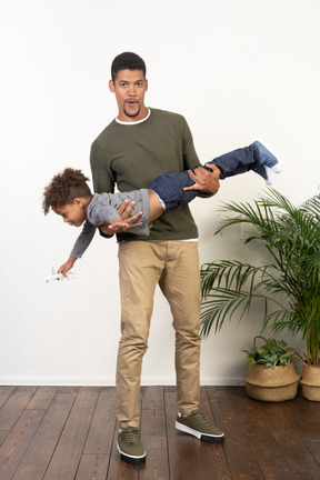 Good looking young man holding a boy in his arms