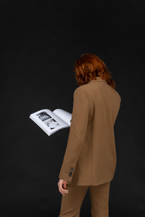 Back view of a woman in a suit reading