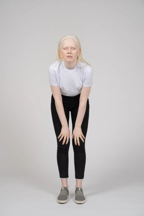 Young woman bending forward with hands on knees