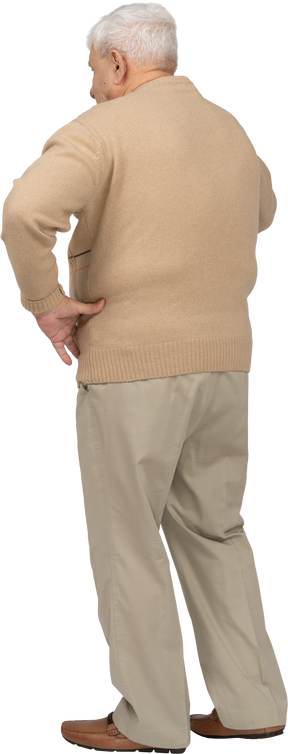 Vista posteriore di un vecchio in abiti casual in piedi con la mano sull'anca