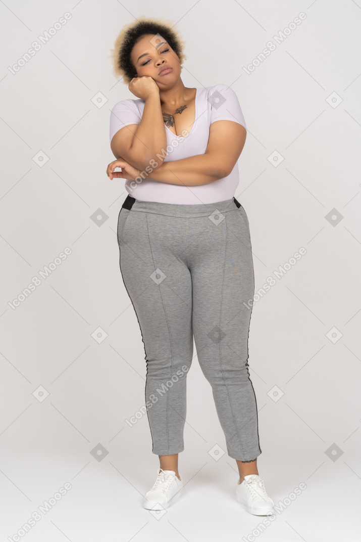 Esausta donna afro dorme in piedi e appoggiata su una mano