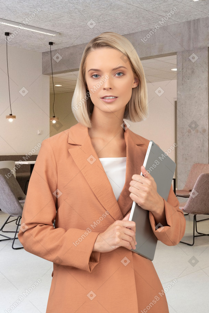 A woman holding a binder in an office