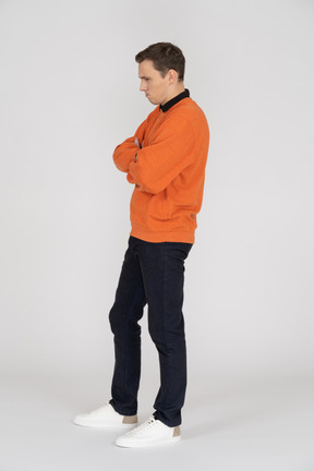 Jeune homme en sweat-shirt orange debout