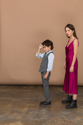 Young woman looking at camera while boy standing near her