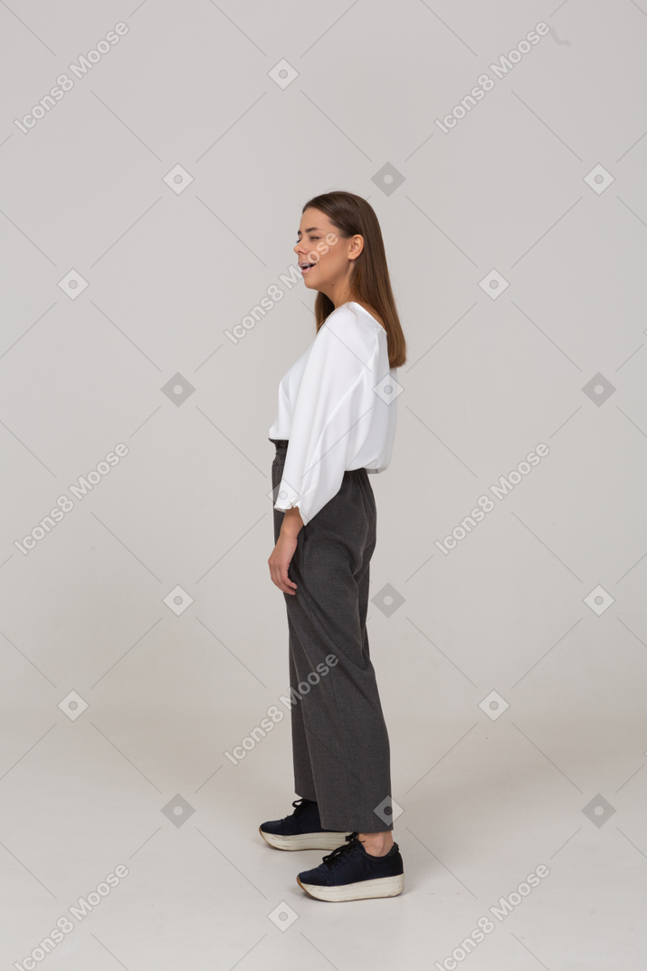 Вид сбоку подмигивающей молодой леди в офисной одежде