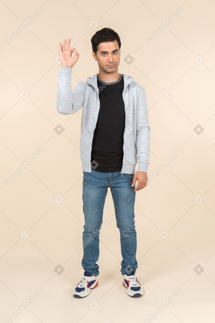 Young caucasian man showing an ok sign
