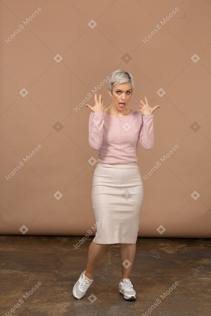Vista frontal de uma mulher impressionada com roupas casuais fazendo caretas