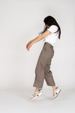 Side view of a young lady in breeches and t-shirt outstretching hands