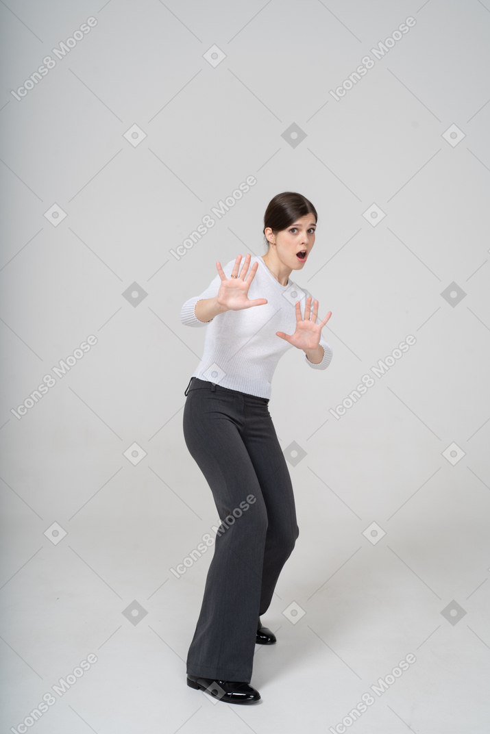 Front view of a scared young woman showing stop gesture