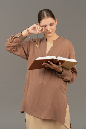 Sleepy young woman reading book