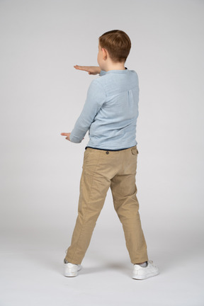 Vista traseira de um menino mostrando o tamanho de algo