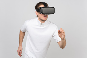 Young man in vr headset running somewhere in virtual reality