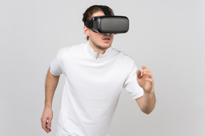 Junger mann im vr-headset läuft irgendwo in der virtuellen realität